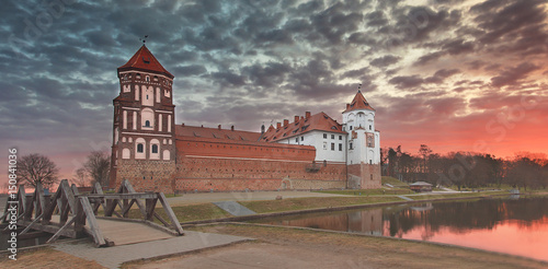 Landscape of an old Mir castle against a colorful sky on a beautiful dawn. photo