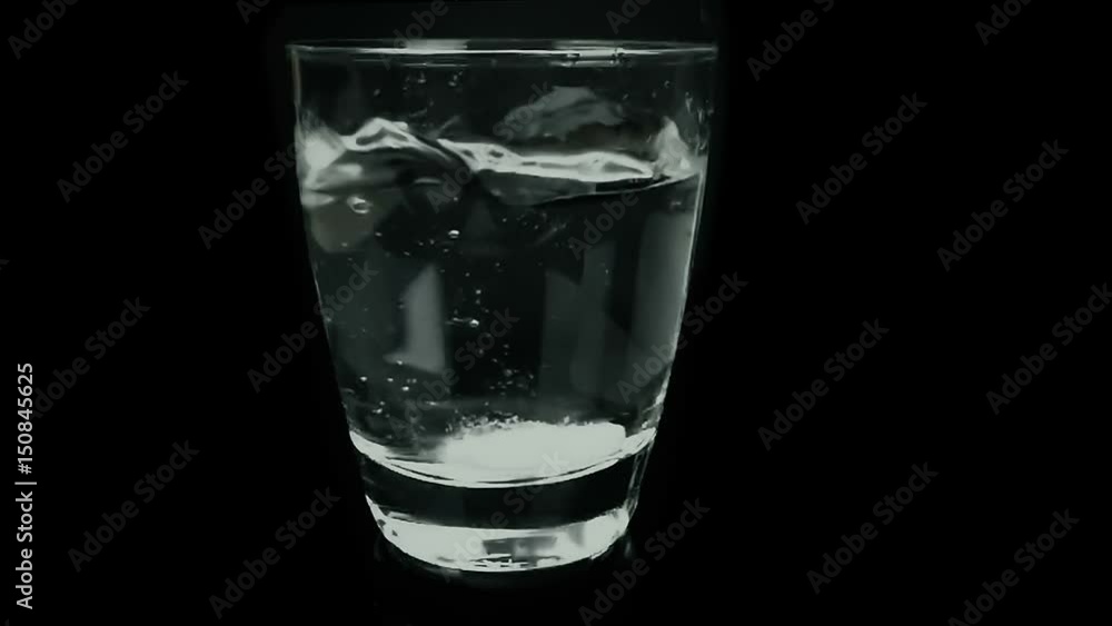 aspirin or effervescent medical pill tablet dropped into the water on black background, slow motion aspirin or effervescent medical pill tablet dropped into the water on black background, slow motion