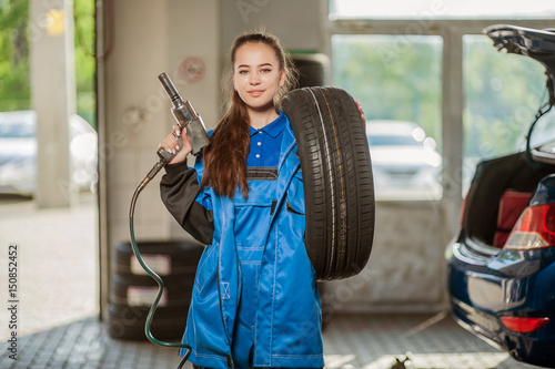 Young beautiful girl at an auto mechanic at work