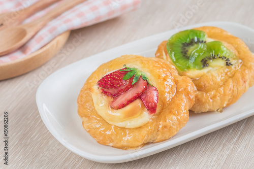 Danish pastry with fruit on plate.