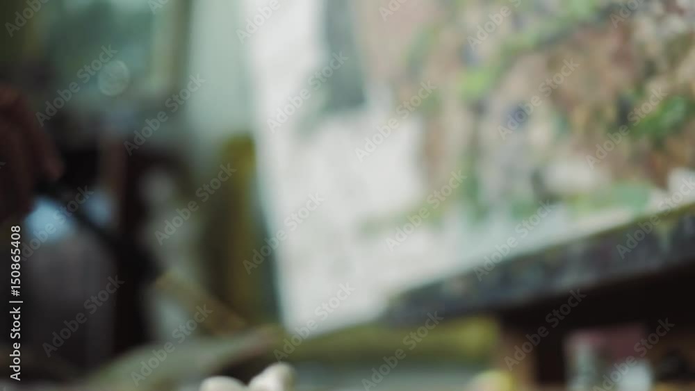 An elderly artist writes a picture in his studio 4k An elderly artist writes a picture in his studio 4k