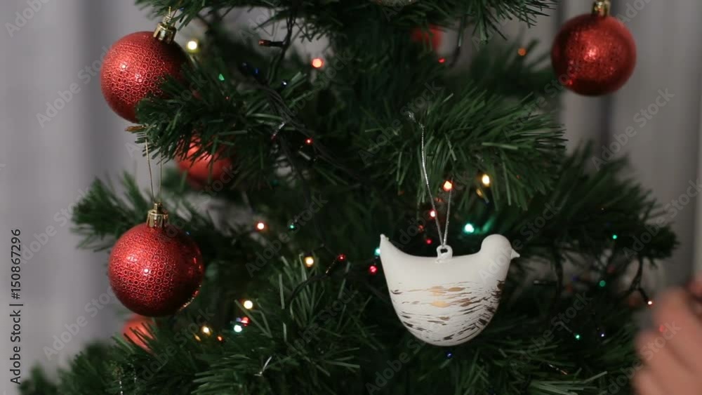 Young woman hands in santa claus hat decorating the Christmas tree on bokeh background. Young woman hands in santa claus hat decorating the Christmas tree on bokeh background.