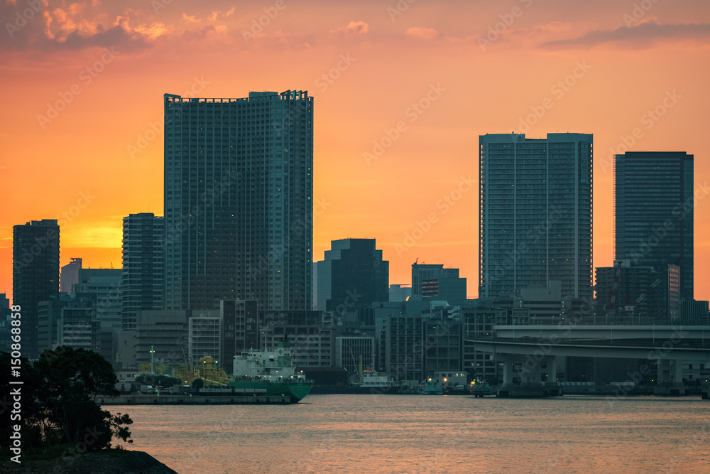 Sunset over office buildings in Tokyo, orange sky