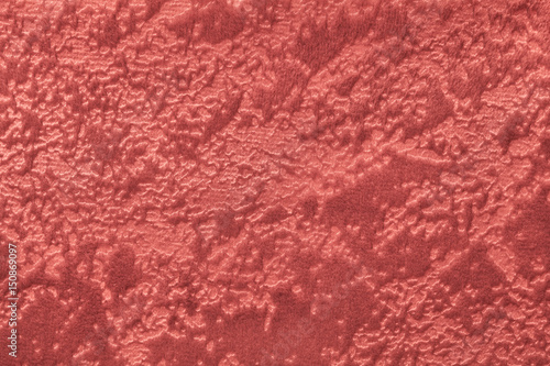 Dark red background from a soft upholstery textile material, closeup.