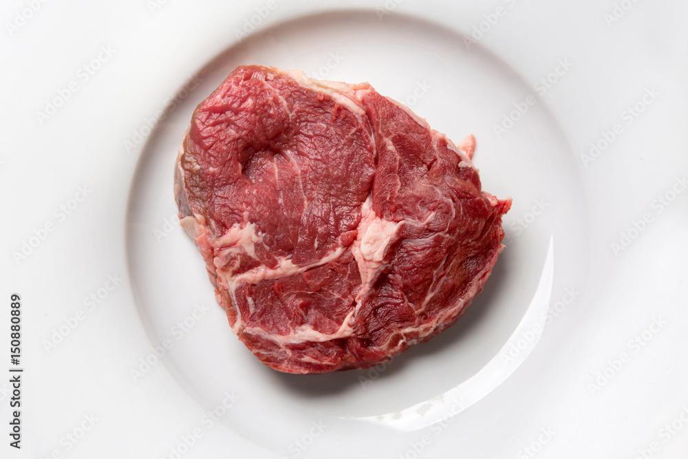 a piece of raw meat on a white plate