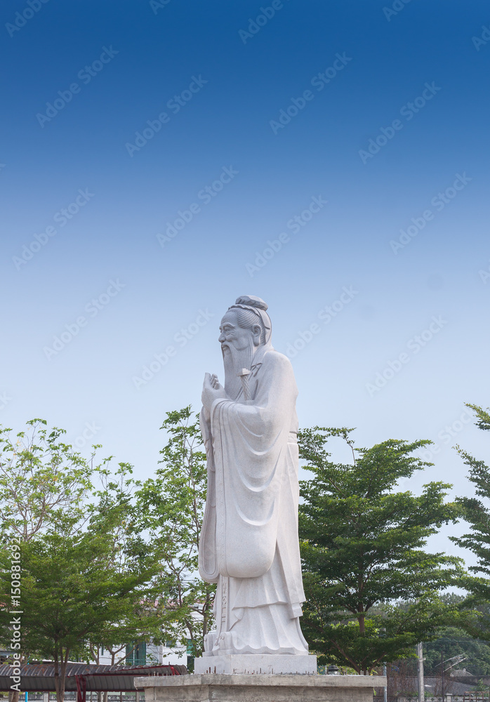 Confucius sculpture / Located in the middle of tall green trees