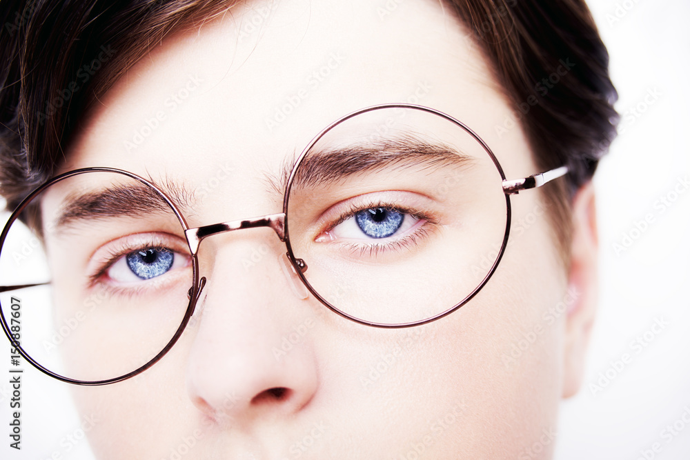 Portrait of a boy wearing eyeglasses blue eyes close, macro studio shot Portrait of a boy wearing eyeglasses blue eyes close, macro studio shot