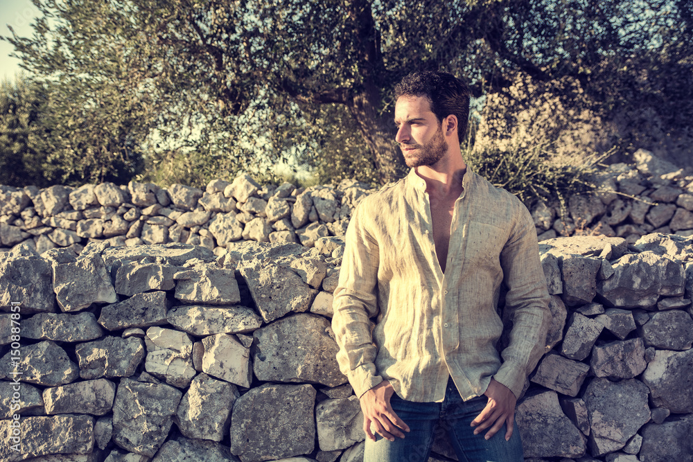 Ruggedly Handsome Man Among Trees with Shirt Unbuttoned Relaxing in Warm Sunlight Ruggedly Handsome Man Among Trees with Shirt Unbuttoned Relaxing in Warm Sunlight