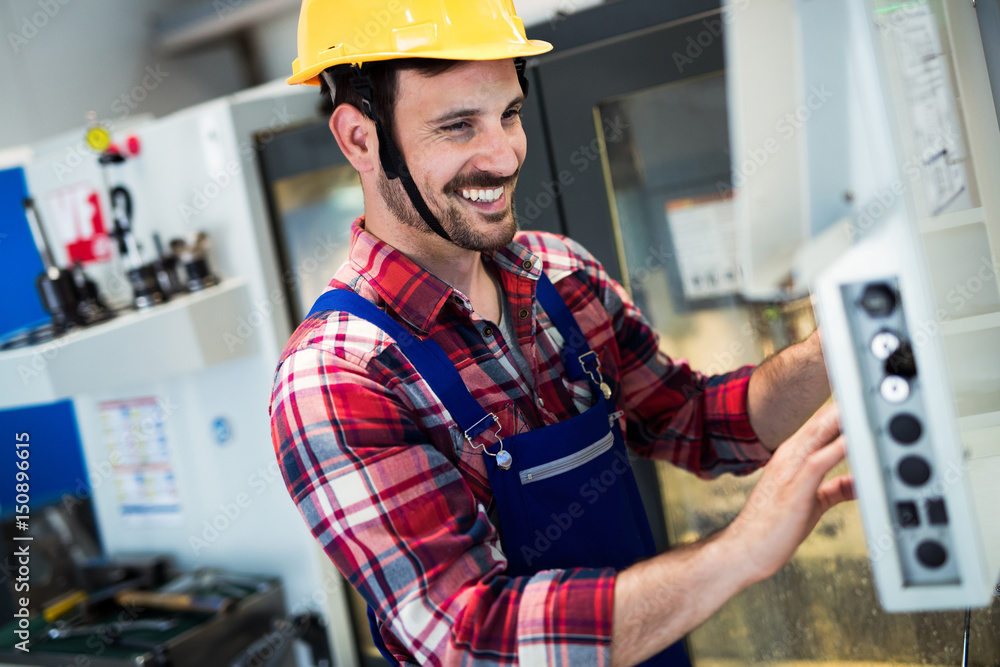 Industry Worker entering data in CNC machine at factory Industry Worker entering data in CNC machine at factory