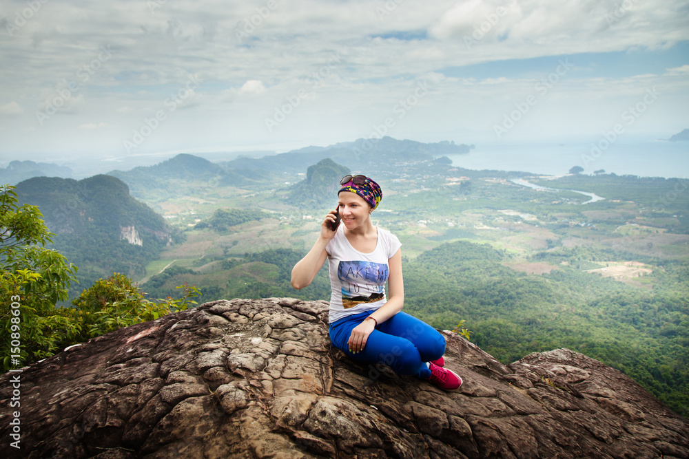 Women travel sit on a cliff on a rich forest mountain. Tab Kak Hang Nak  Hill Nature Trail. Stock Photo | Adobe Stock