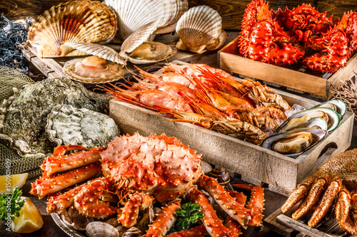 Seafood cuisine plate as an ocean gourmet dinner background. Crab, seashells, oysters, shrimp and other seafood delicacies. photo
