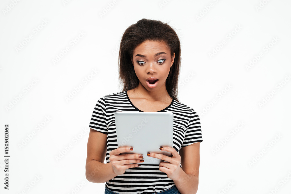 Shocked young african woman using tablet computer. Shocked young african woman using tablet computer.