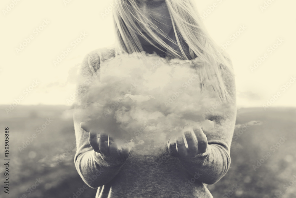 Surreal moment, solitary woman holding in her hands a gray cloud - obrazy, fototapety, plakaty 