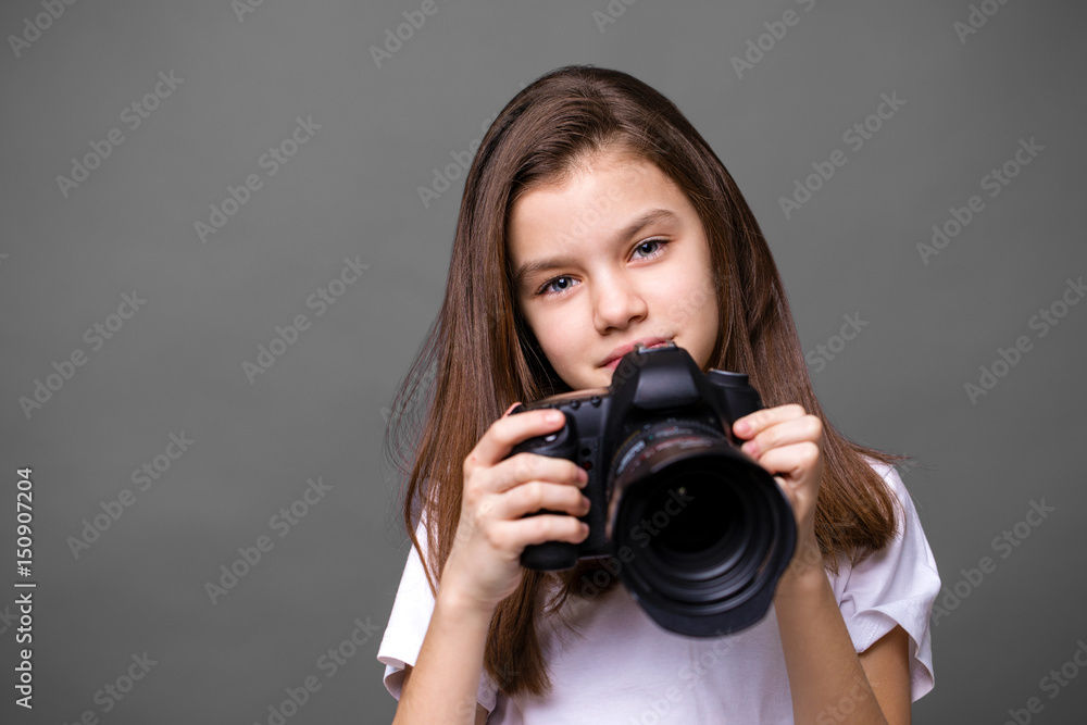 Cute brunette little girl holding an photo camera Cute brunette little girl holding an photo camera