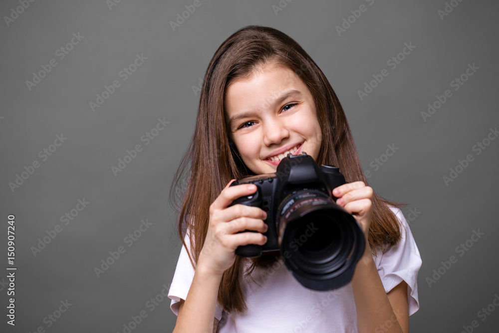 Fototapeta premium Cute brunette little girl holding an photo camera