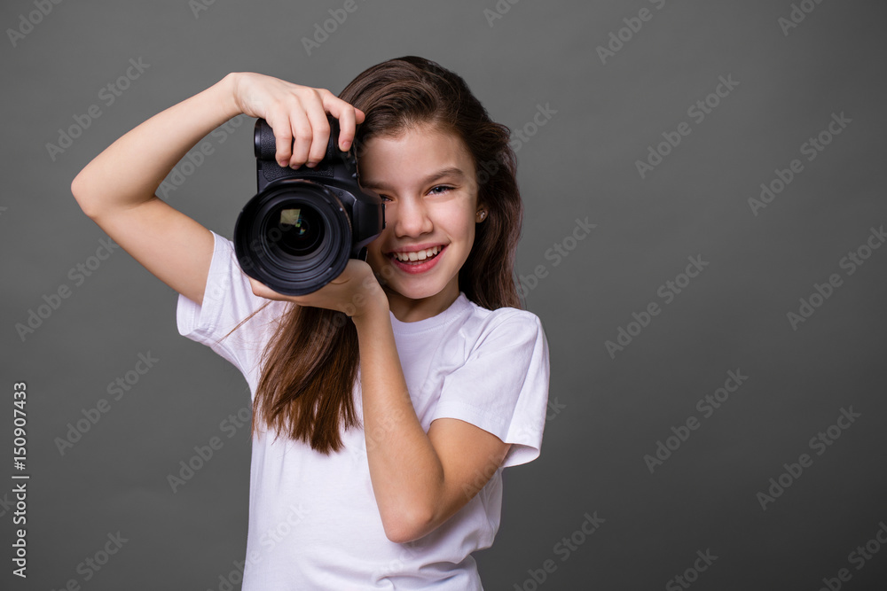 Cute brunette little girl holding an photo camera Cute brunette little girl holding an photo camera