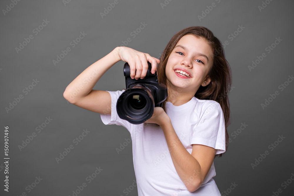 Cute brunette little girl holding an photo camera Cute brunette little girl holding an photo camera