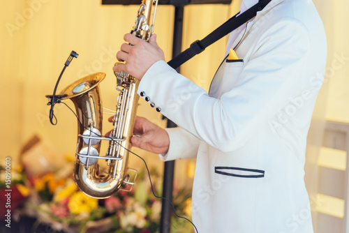 Photography Saxophonist in white jacket plays the saxophone