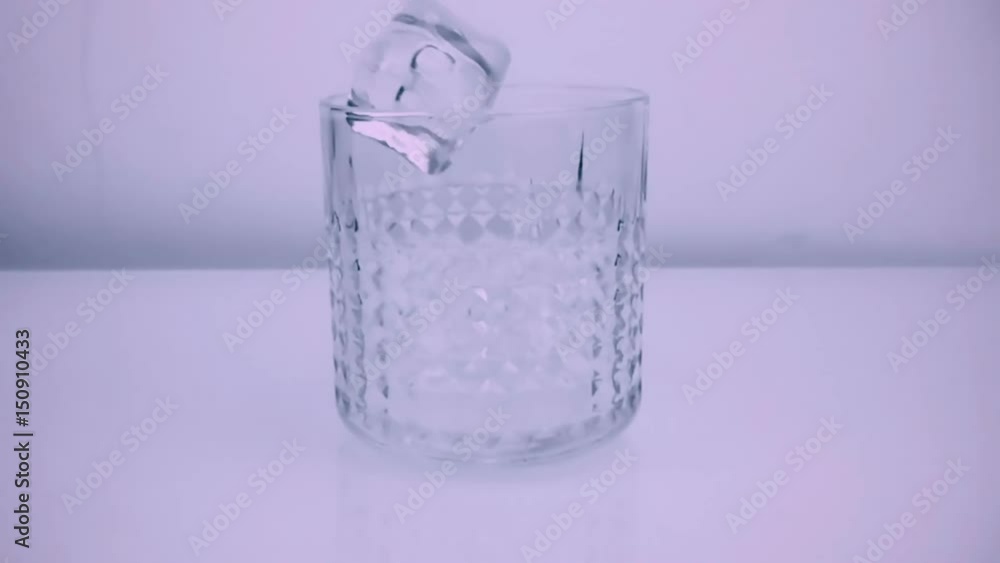 ice cubes falling down in whiskey glass, slow motion, on white background ice cubes falling down in whiskey glass, slow motion, on white background