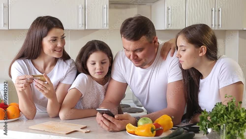 Happy Family Makes Purchases in Internet using a Credit Card. Happy Family Makes Purchases in Internet using a Credit Card.