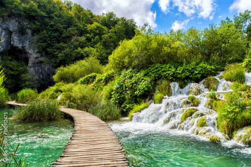 Fototapeta Naklejka Na Ścianę i Meble -  Tourist route on the wooden flooring in the famous Plitvice Lakes National Park across amazing colored water, green and waterfalls, nature background for guide book or poster