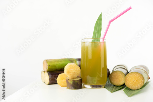 Fresh sugar cane juice in glass on white background
