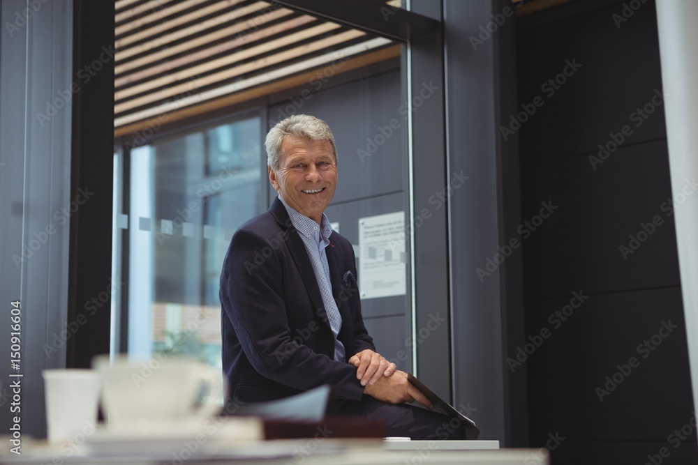 Portrait of smiling businessman holding clipboard