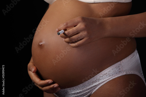 Pregnant woman holding cigarette