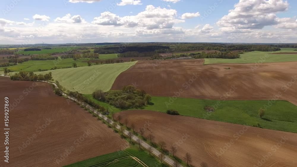 Aerial view of a country road in beautiful agricultural fields under blue sky - germany Aerial view of a country road in beautiful agricultural fields under blue sky - germany