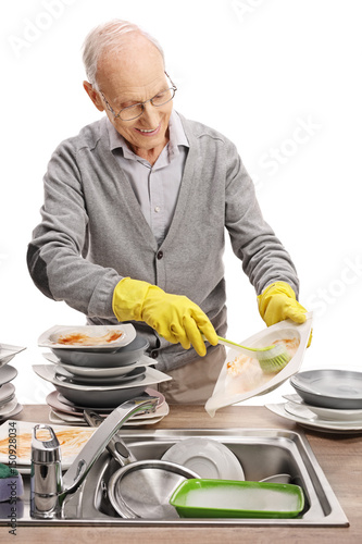 Fotografie Elderly man doing the dishes