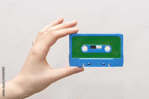 hand holding blue cassette tape isolated in white background