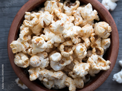 popcorn in a bowl on a wooden background