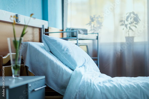 side view of empty hospital bed in clinic chamber photo