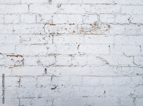 White brick wall displaying blemishes and cracks