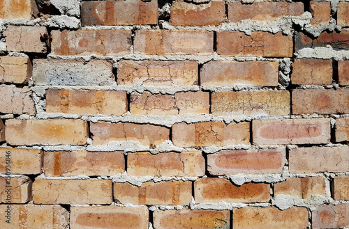 Badly laid brick wall with cracks and gaps