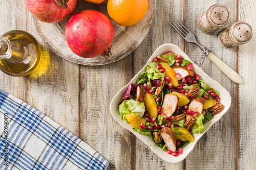 Spring salad with chicken, pomegranate, orange, pecan nuts and honey.