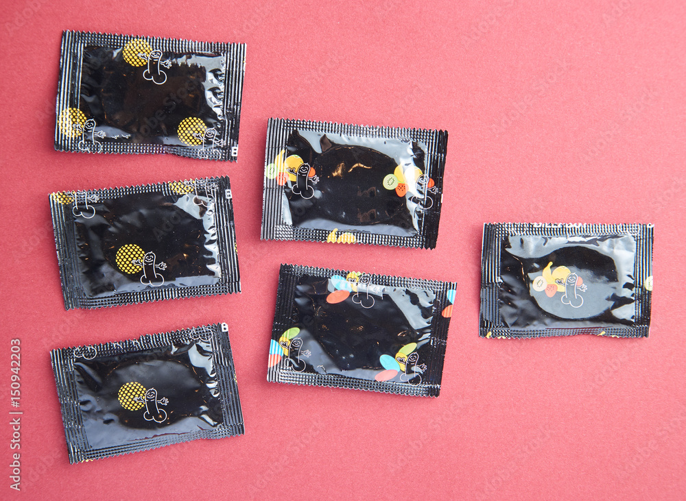 Obraz premium Condoms on red background with copy space. Having safe sex.