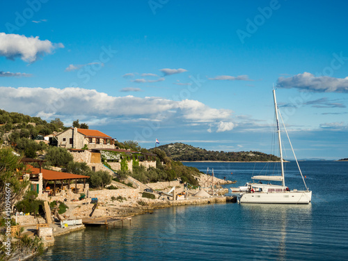 Catamaran docked in a bay with restaurant in Croatia at sunset, Kaprije island