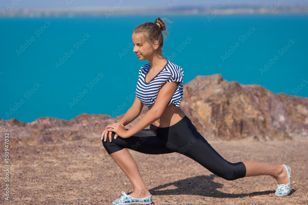 Girl are doing stretching on the beach. Fitness training. The concept of a healthy lifestyle, sports Girl are doing stretching on the beach. Fitness training. The concept of a healthy lifestyle, sports