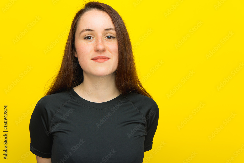 Happy young woman in black T-shirt on yellow background Happy young woman in black T-shirt on yellow background