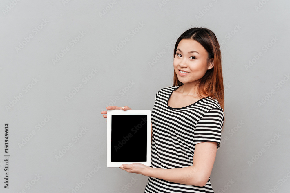 Cheerful asian woman showing tabler with blank screen Cheerful asian woman showing tabler with blank screen