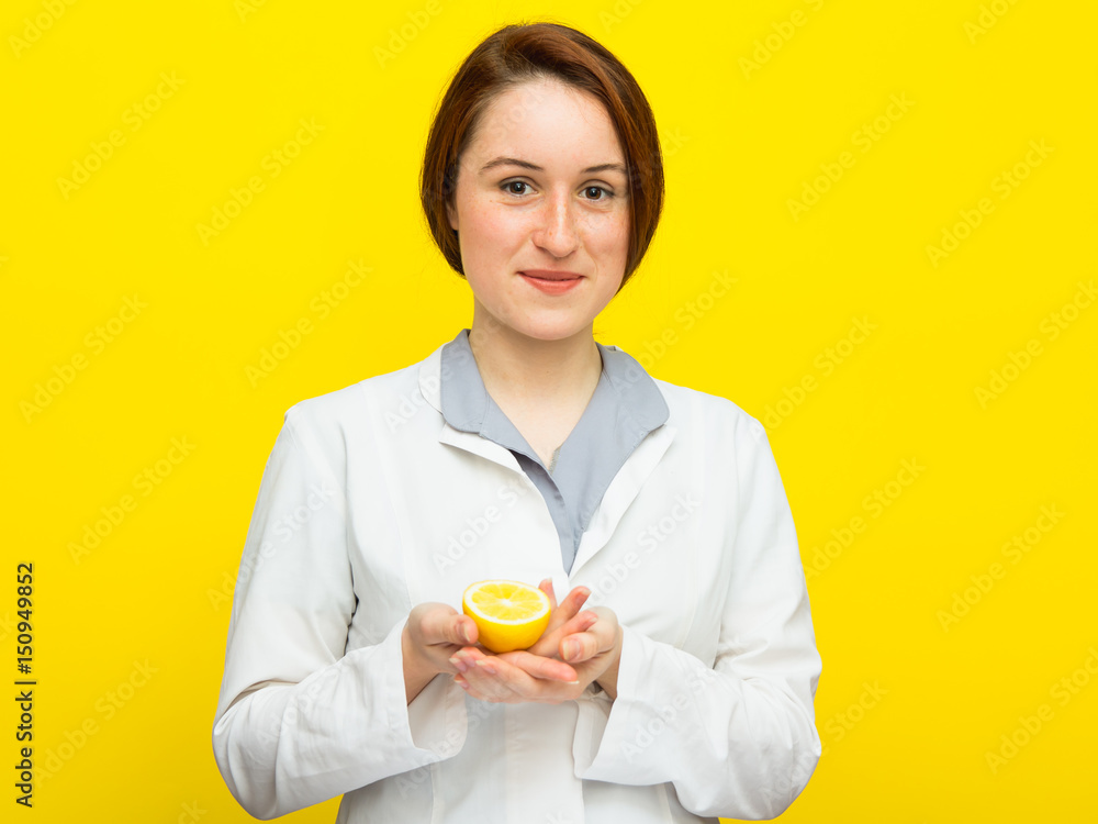 Young female nutritionist with half citrus on yellow background Young female nutritionist with half citrus on yellow background