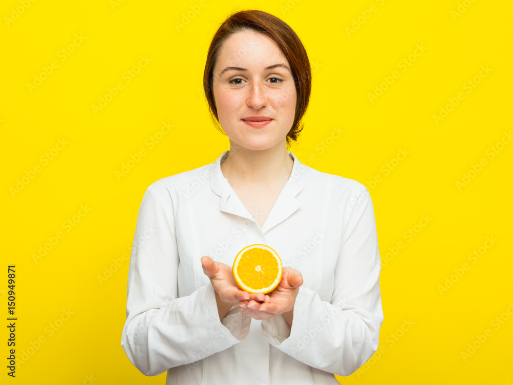 Young female nutritionist with half citrus on yellow background Young female nutritionist with half citrus on yellow background