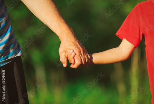 grandmother and grandson holding hands in nature