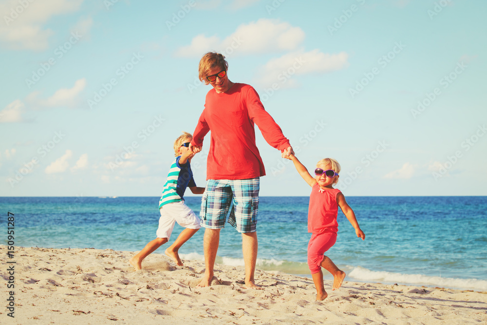 father with son and daughter play at beach father with son and daughter play at beach