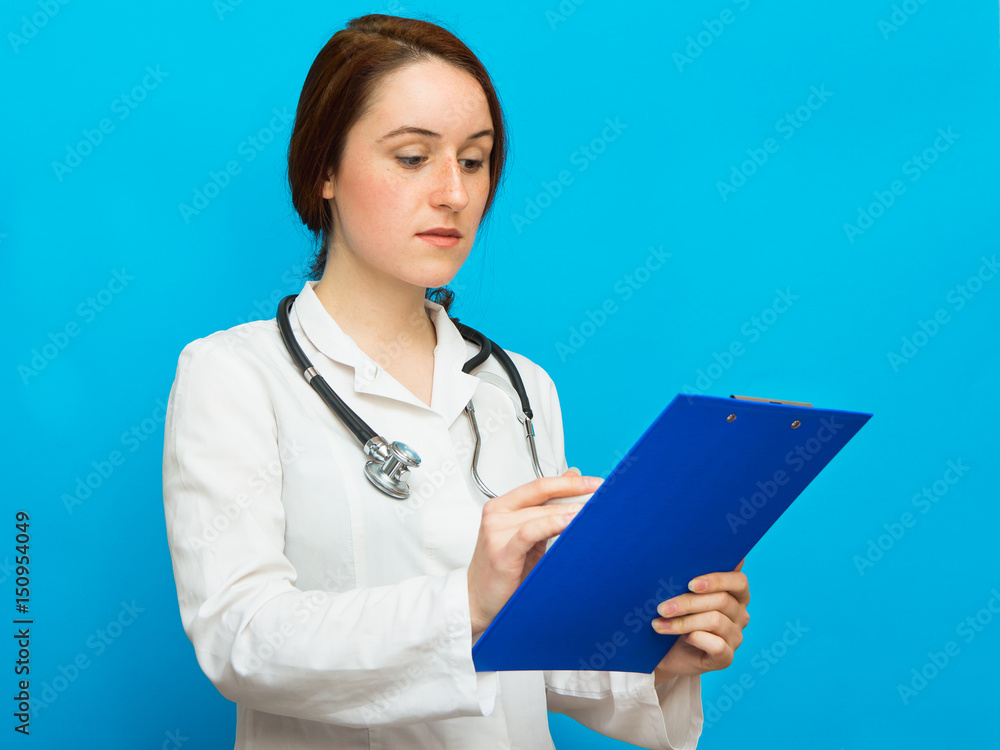 Young beautiful female doctor showing blank area for sign or copyspace, blue background Young beautiful female doctor showing blank area for sign or copyspace, blue background