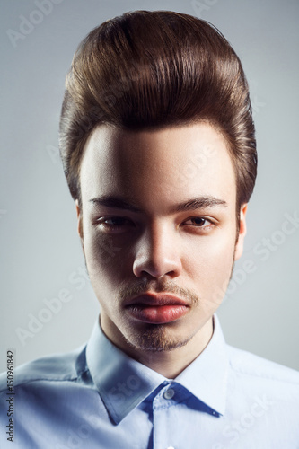 Portrait of young man with retro classic pompadour hairstyle. studio shot. looking at camera. photo