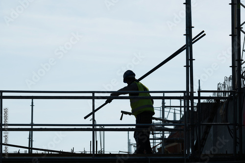 chantier construction travaux construire maison manutention ouvrier maçon sécurité barre fer rambarde barrière métal silhouette contre jour