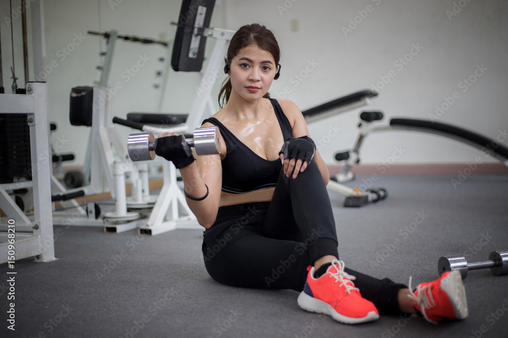 Fototapeta premium beautiful muscular fit woman exercising building muscles and fitness woman doing exercises in the gym. Fitness - concept of healthy lifestyle,soft focus
