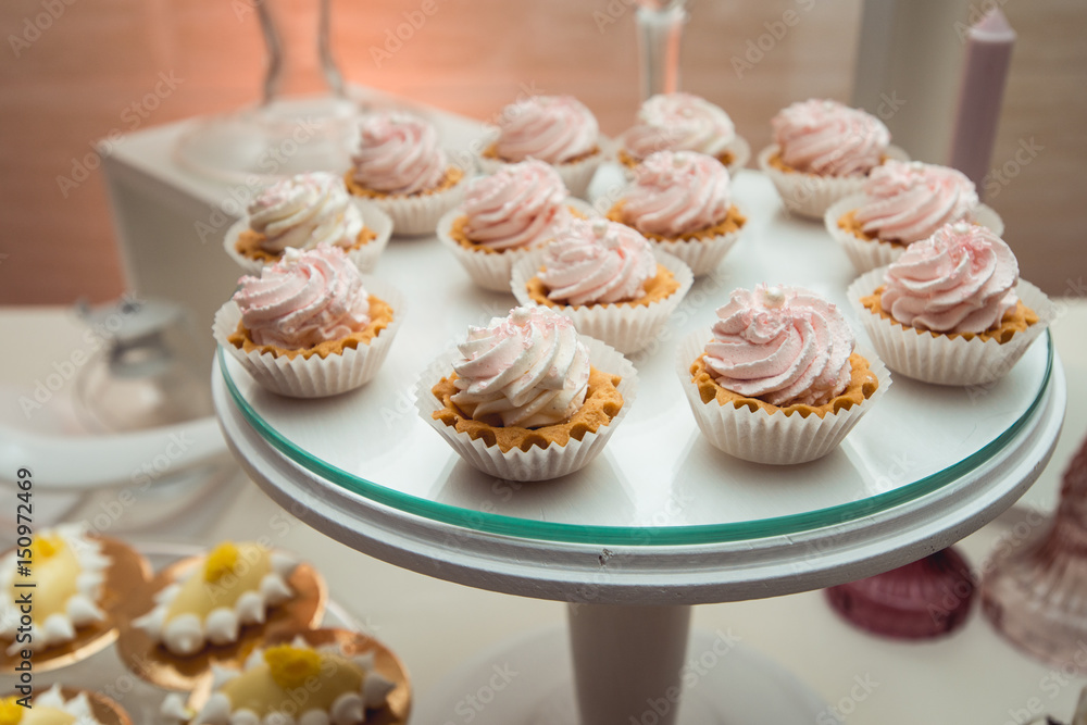 glass stand with cupcakes on a wedding candy bar table